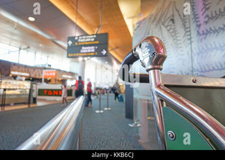 Auckland, Nouvelle-Zélande - 27 novembre, 2017 ; poignée de trolley contre dans un arrière-plan du terminal de l'aéroport fait allusion à l'expérience de voyage d'air Banque D'Images