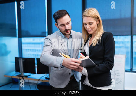 Les jeunes gens d'affaires et de parler de l'affichage de documents Banque D'Images