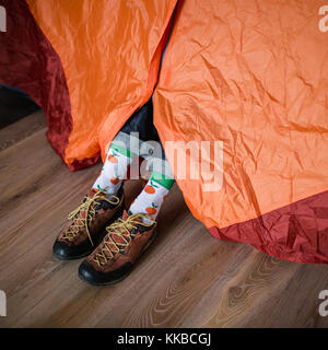 Pieds de Happy Socks. man est relaxant près de tente et réchauffe ses pieds dans happy socks. Banque D'Images