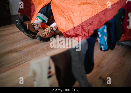 Pieds de Happy Socks. man est relaxant près de tente et réchauffe ses pieds dans happy socks. Banque D'Images