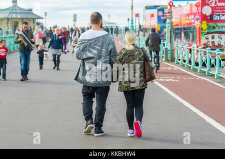 Young couple holding hands marchant le long d'une promenade de bord de mer. Banque D'Images