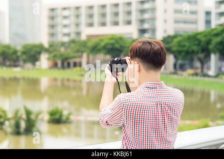 La moitié de la longueur de young asian man piscine dans la ville Prendre photo Banque D'Images