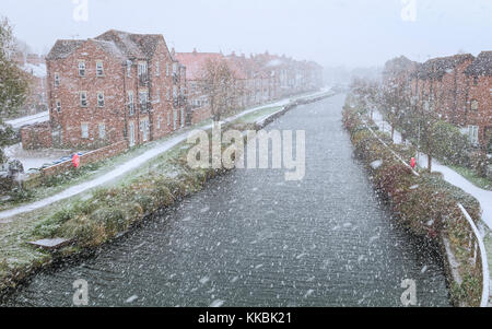 La neige tombe sur la beck/canal avec une diffusion de la lumière de la neige plus de maisons de village et sentier à Beverley, Yorkshire, UK. Banque D'Images