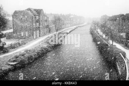 La neige tombe sur la beck/canal avec une diffusion de la lumière de la neige plus de maisons de village et sentier à Beverley, Yorkshire, UK. Banque D'Images