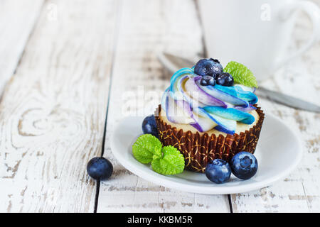 Cupcakes vanille délicate avec de la crème et les baies sur un fond de bois blanc Banque D'Images