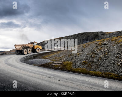 La conduite de camions Moxy grand jaune à travers une vallée montagneuse road. Banque D'Images