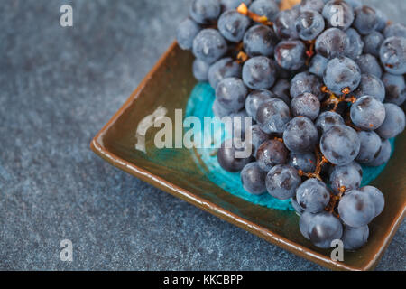 Cépage rouge sur une plaque sombre. bleu raisin, raisins noirs Banque D'Images