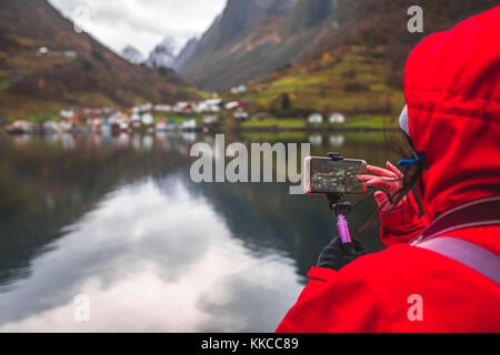 Prise de photos touristiques sur un smartphone de fjords magnifiques au cours de la Norvège en un mot magnifique croisière à travers l'aurlandsfjord et t Banque D'Images