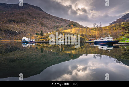 Grand traversier pour passagers et petit bateau ancré dans le port sur la rive dans petit village Flam, Norvège Banque D'Images