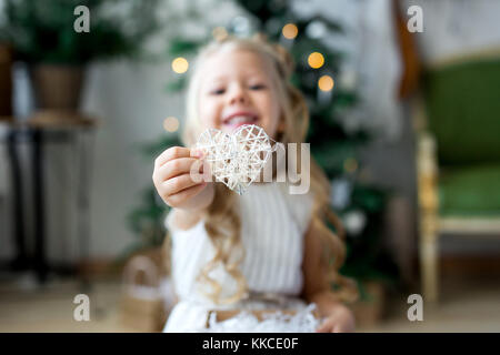 Un peu jolie fille rêves de cadeaux. une jolie fille faire un souhait. joyeux noël et de bonnes vacances Banque D'Images