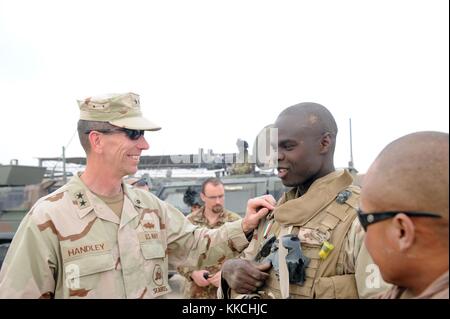 Le contre-amiral Mark A Handley, commandant de la 1re Division de construction navale NCD commente un patch italien porté par l'électricien de construction de 2e classe Anthony Williams, de Miami, FLA, un Seabee affecté au bataillon de construction navale mobile NMCB 11, province de Farah, Afghanistan. Image reproduite avec l'aimable autorisation du spécialiste des communications de masse 1re classe Jonathan Carmichael/US Navy. 2012. Banque D'Images