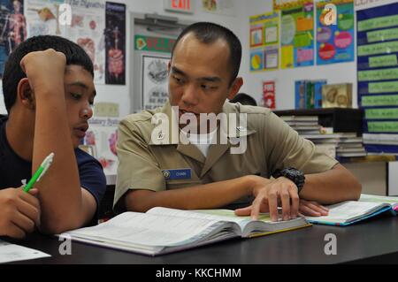 Spécialiste des questions de personnel seaman fung chan, affecté à l'adjudication du sous-marin USS emory s land comme 39, explique concepts mathématiques et les formules d'un étudiant de jose rios middle school dans le cadre du programme de tutorat, des chercheurs samedi, piti guam. Image courtoisie de technicien de systèmes d'information 2e classe alexavier allen/us navy. 2012. Banque D'Images