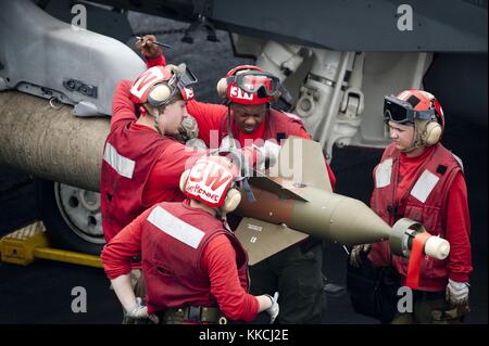 Des soldats de l'aviation affectés à l'Eagles of Strike Fighter Squadron VFA 115 arment un GBU-16 Paveway II sur un F/A-18E pendant les opérations de vol à bord du porte-avions USS George Washington CVN 73, Océan Pacifique, 2012. Image reproduite avec l'aimable autorisation du spécialiste des communications de masse de 3e classe Paul Kelly/US Navy. Banque D'Images