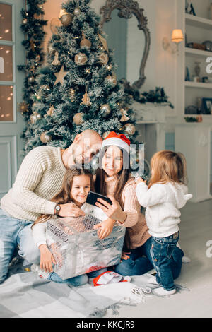 La famille joyeux noël bande dessinée faisant et selfies montrant langues Banque D'Images