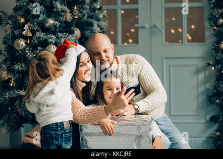 Smiling mother, father and little girl making avec caméra selfies Banque D'Images