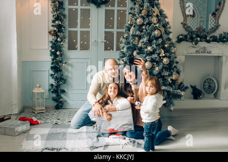 La famille joyeux noël bande dessinée faisant et selfies montrant langues Banque D'Images