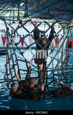 Les marines français affecté à la 5e Régiment Étranger Interarms, Djibouti, monter un filet dans le cadre d'un obstacle pendant un cours de commando désert français évaluation de présélection à Montclair, Djibouti, 22 novembre 2017. Les autres marines et 30 soldats de la Garde nationale de l'Armée américaine affecté à la 3e Bataillon, 144e Régiment d'infanterie, Task Force Bayonet, Camp Lemonnier, Djibouti, vu que chaque équipe de trois à cinq membres est passé par l'évaluation de l'eau. Chaque service avait à remplir tous les obstacles à base d'eau afin de soutenir la concurrence dans les deux semaines de désert français Commando C Banque D'Images