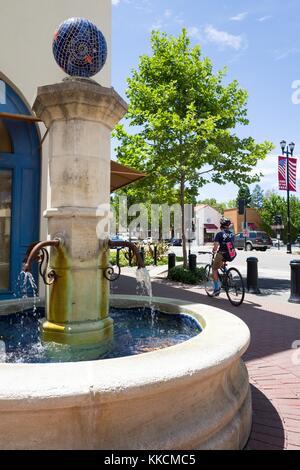 Un cycliste passe par une fontaine de style méditerranéen sur une place au large du boulevard Mount Diablo à Lafayette, Californie, l'une des communautés les plus riches de la région de la baie de San Francisco, Lafayette, Californie, 2016. Banque D'Images