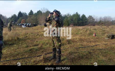 Le soldat roumain affecté au détachement de défense aérienne de la base terrestre de l’armée, « Black Bats », sert un chef d’équipe et envoie le commandement du tir à l’équipage du canon dans une aire de tir en direct à la zone d’entraînement de Wierzbiny, en Pologne, le 24 novembre 2017. Banque D'Images