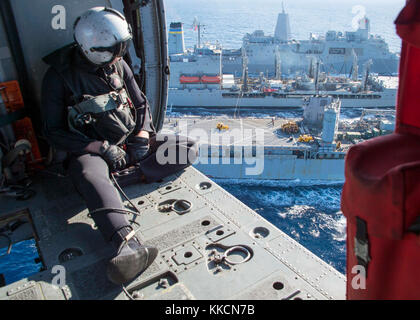 Océan Atlantique (nov. 26, 2017) Naval Air Crewman (hélicoptère) 3e classe Austin Rivera, affecté à l'Escadron d'hélicoptères de combat de la Mer 28, observe que le dock de transport amphibie USS New York (LPD 21), haut, et le navire de débarquement amphibie dock USS Oak Hill (LSD 51), bas, recevoir le carburant de la reconstitution de la flotte oiler USNS Big Horn (T-AO 198) au cours d'un ravitaillement en mer. Le navire d'assaut amphibie USS Iwo Jima (DG 7), composantes de l'Iwo Jima Groupe amphibie et la 26e unité expéditionnaire de marines sont la réalisation d'une unité de formation composite combinée de l'exercice physique qui l'culminati Banque D'Images