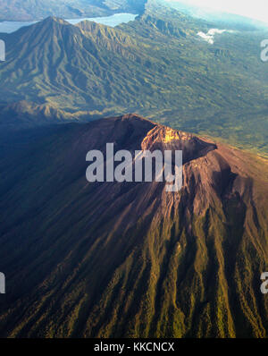 Le cratère du Mont Agung vu de la fenêtre de l'avion avec le mont abang et mont Batur en arrière-plan. Banque D'Images