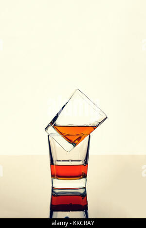 De whisky, de rhum ou de cognac dans deux verres sur la table avec réflexion. concept : l'alcool de luxe. Banque D'Images