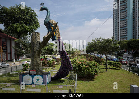 Une statue de paon appuyé contre un arbre, à afficher dans le centre de Singapour sur une route à deux voies Banque D'Images