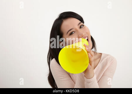 Malay woman using megaphone sur le fond blanc Banque D'Images