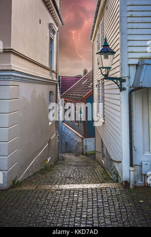 Rue pavée étroite entre les anciennes maisons traditionnelles blanches dans la vieille ville de Bergen, Norvège Banque D'Images