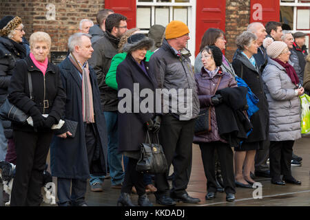 Close-up de personnes bordant la route debout à côté de route dans le froid, avant de défilé militaire à l'extérieur de la cathédrale de York, North Yorkshire, England, UK. Banque D'Images