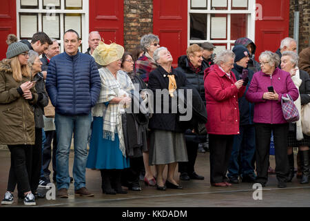 Close-up de personnes bordant la route debout à côté de route dans le froid, avant de défilé militaire à l'extérieur de la cathédrale de York, North Yorkshire, England, UK. Banque D'Images