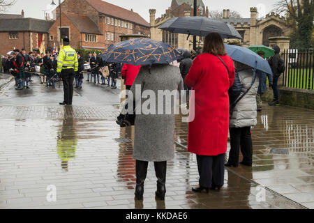 Vue arrière de regarder les gens pipe band & anciens combattants de guerre la queue avant le début du défilé commémoratif - par la cathédrale de York North Yorkshire, Angleterre, Royaume-Uni. Banque D'Images