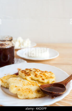 Curd crêpes, fromage à pâte fraîche, confiture de prunes et en pot et sur cuillère en bois sur la table en bois et copier l'espace. Banque D'Images