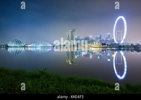 Vue de nuit sur le centre-ville de Singapour à partir de l'ensemble de la marina, avec le quartier des affaires, hôtels, jardins et une grande roue. Banque D'Images