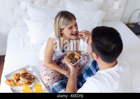 Young attractive couple having breakfast in bed Banque D'Images