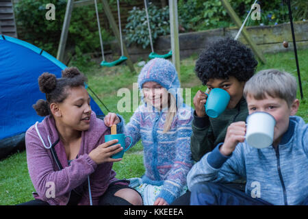 Événement sleepout big wild pix . Des images de jeunes enfants/ les enfants et les parents dans leur jardin à l'arrière du milieu de l'après-midi jusqu'à la nuit, profitent d'activités, par exemple, la fabrication d'un den, à la recherche de bugs, publiant de la nourriture pour chiens pour les hérissons, faire griller des guimauves autour d'un feu de camp, espèce de piégeage, à la recherche de la faune nocturne. Banque D'Images