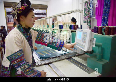 Qiandongnan, province chinoise du Guizhou. 1er décembre 2017. Une femme de l'ethnie Miao travaille sur une machine pour faire des broderies au village de ma'an du comté de Congjiang, province du Guizhou du sud-ouest de la Chine, Dec. 1, 2017. La conception informatique et le travail mécanique ont contribué à promouvoir la transformation de l'industrie traditionnelle de la broderie à la main. Crédit : Wu Dejun/Xinhua/Alamy Live News Banque D'Images