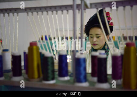 Qiandongnan, province chinoise du Guizhou. 1er décembre 2017. Une femme de l'ethnie Miao travaille sur une machine pour faire des broderies au village de ma'an du comté de Congjiang, province du Guizhou du sud-ouest de la Chine, Dec. 1, 2017. La conception informatique et le travail mécanique ont contribué à promouvoir la transformation de l'industrie traditionnelle de la broderie à la main. Crédit : Wu Dejun/Xinhua/Alamy Live News Banque D'Images