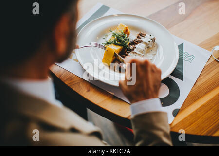 Handsome middle-aged businessman having lunch in restaurant Banque D'Images