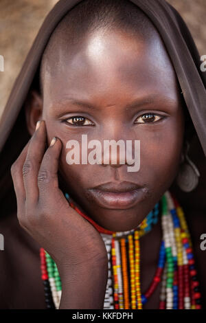 Portrait de belle fille de la tribu arbore avec sa main sur sa joue, village isolé dans la vallée de l'Omo, en Éthiopie, en Afrique. Banque D'Images