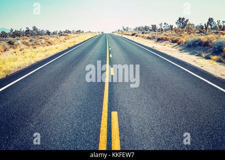 Route dans le parc national de Joshua tree, l'accent sur l'asphalte, les tons de couleur photo, USA. Banque D'Images