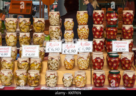 Affichage des légumes en pot italien spécialisé dans des bocaux en verre sur l'écran dans un marché de rue avec de l'ail, les artichauts et poivrons peperoni Banque D'Images