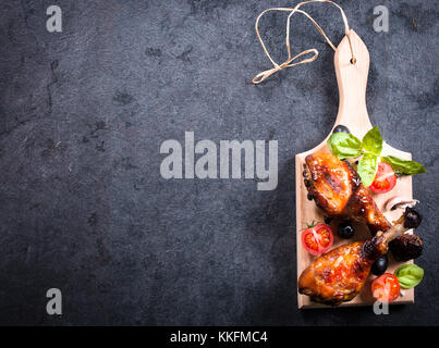 Pilons de poulet au miel et épices sur sur planche de bois,espace blanc sur le côté gauche Banque D'Images