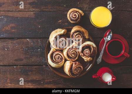 Pâtisserie au chocolat, tasse de café et jus d'orange sur fond de bois avec l'espace blanc Banque D'Images