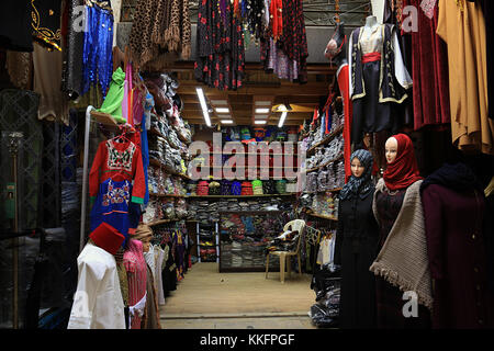 Un étal de vêtements avec divers vêtements et foulards dans un vieux souk à Tripoli, Liban. Banque D'Images