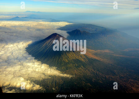 Mont Agung vu de la fenêtre de l'avion vol tôt le matin de Denpasar à Makassar. Mont Batur et son immense caldeira vu en arrière-plan. Banque D'Images