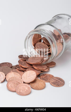 Quelques sous de cuivre à partir de UK en cascade pot en verre. Enregistrement de pièces d'argent, table de cuisine, s'occuper des pennies, Pennywise, l'épargne, 1p défi penny Banque D'Images