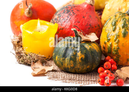 L'automne mini potirons et baies sur fond blanc avec bougie allumée Banque D'Images