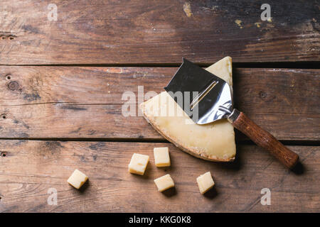 Gros morceau et de petits cubes de fromage avec du fromage belge à couteau sur fond de bois. vue d'en haut. Banque D'Images