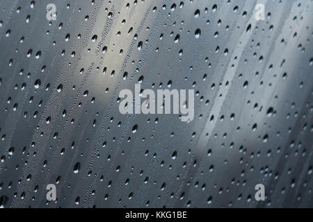 Close-up de bandes diagonales de gouttes de pluie sur une fenêtre de buée Banque D'Images